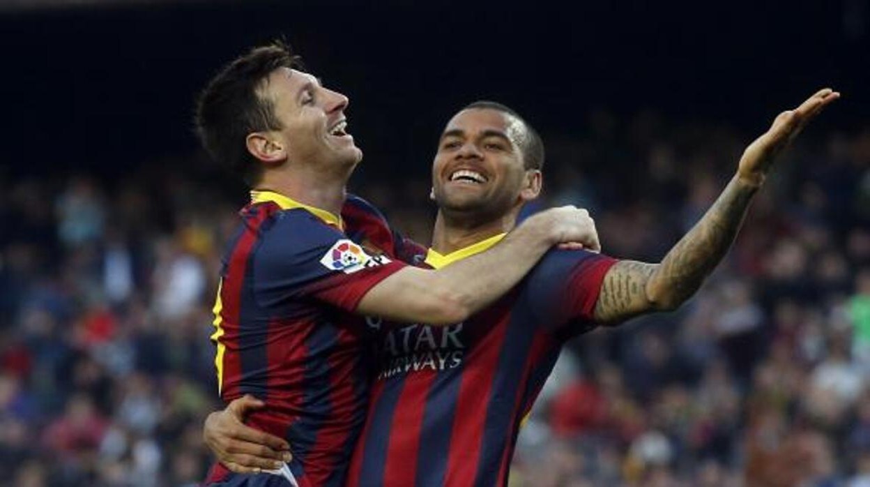 Messi y Alves celebran un gol