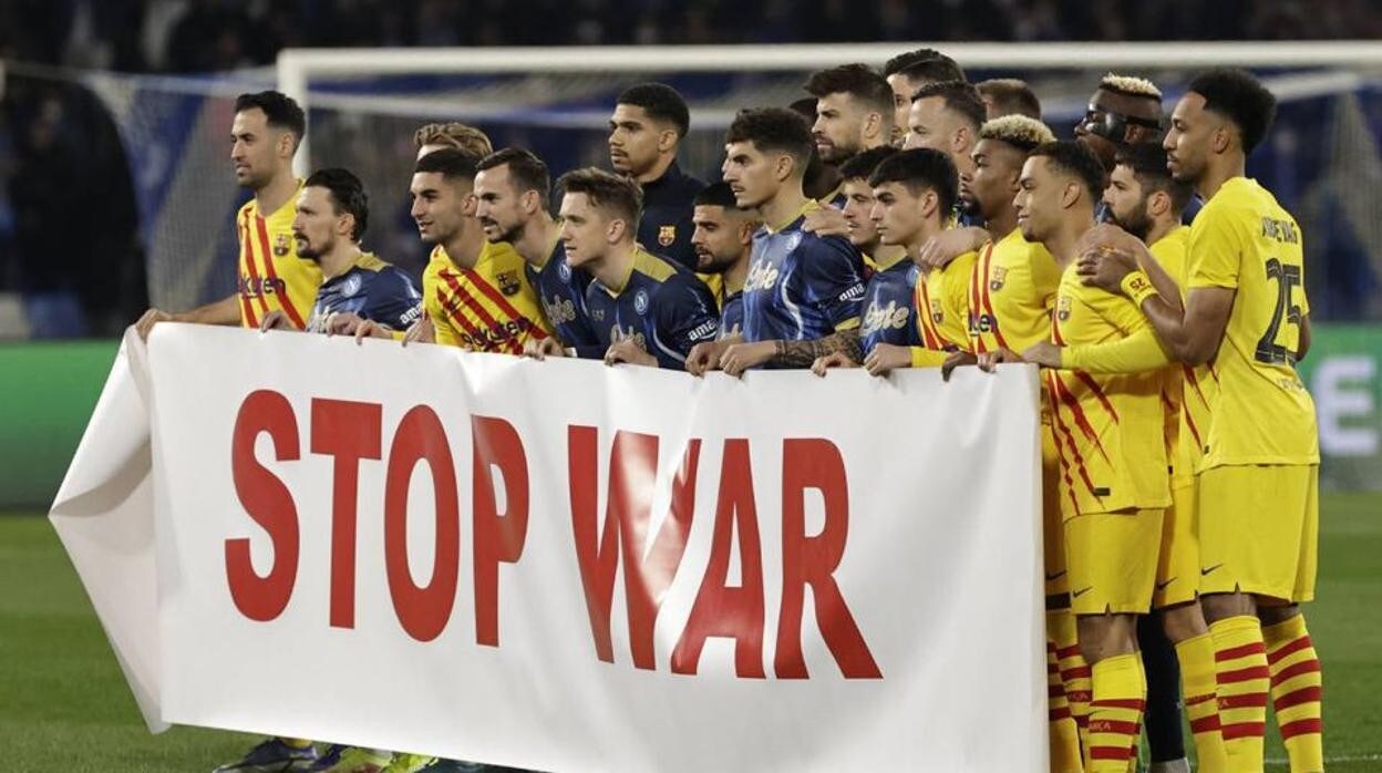 Los jugadores del Barcelona muestran una pancarta contra la guerra antes del partido ante el Nápoles