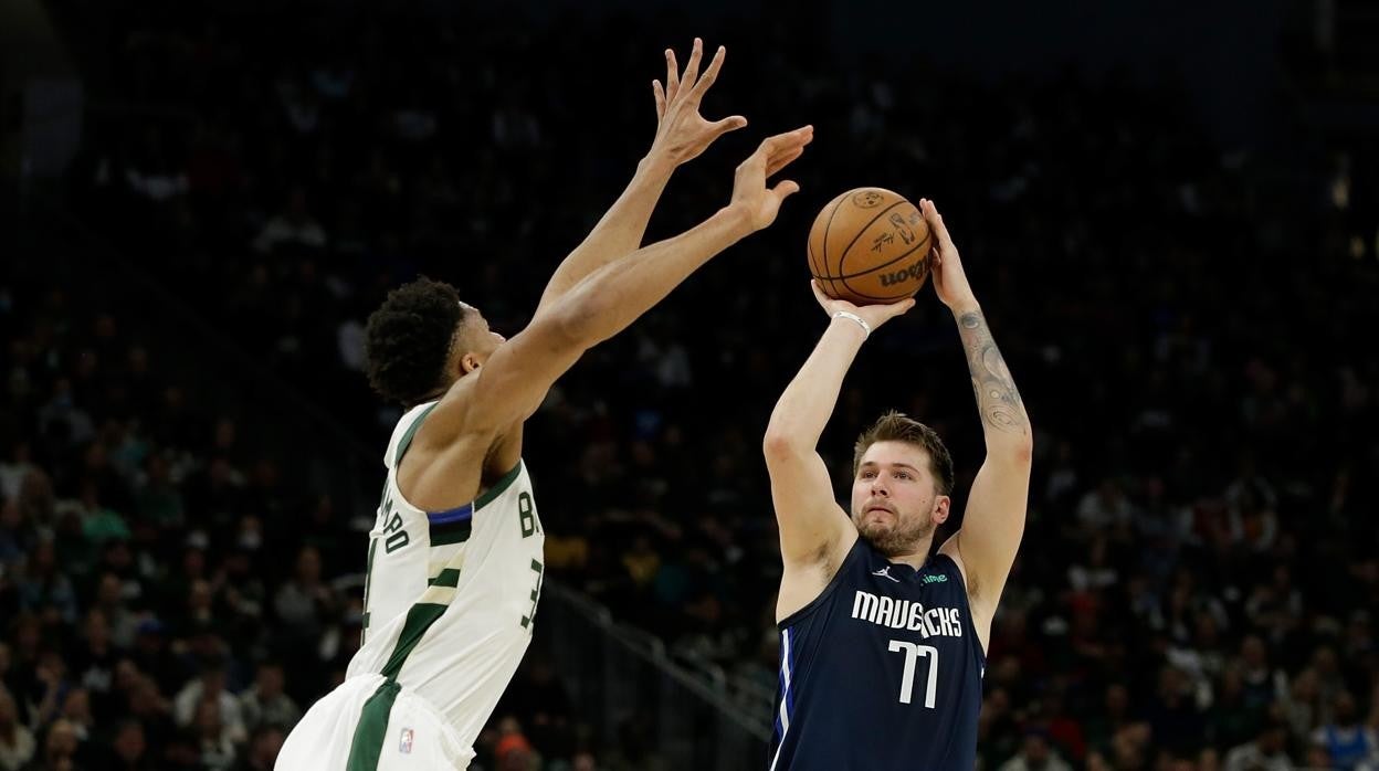 Doncic lanzando de tres sobre la defensa de Antetokounmpo