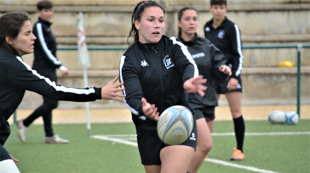 Una jugadora lanza el oval en las instalaciones de uso universitario