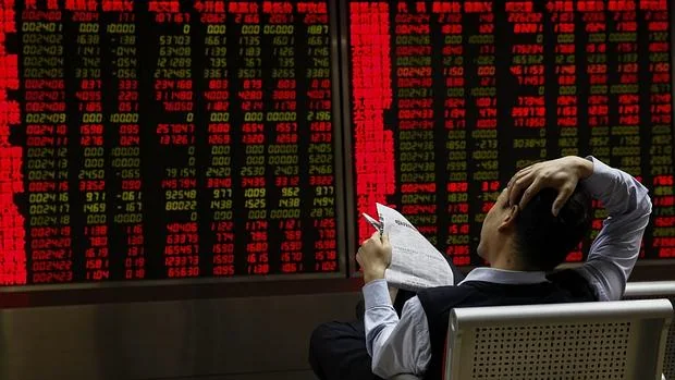 Inversores observan la información bursátil en una correduría en Pekín