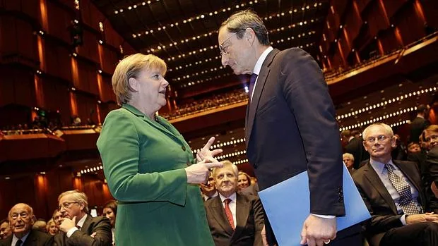 Angela Merkel, canciller alemana, y Mario Draghi, presidente del BCE, conversan en un acto