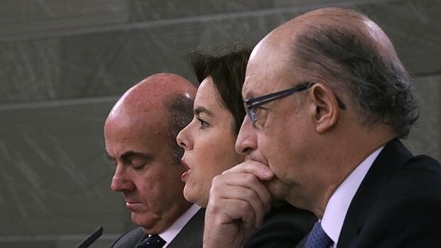 El ministro de Economía, Luis de Guindos, la vicepresidenta del Gobierno, Soraya Sáenz de Santamaría, y el ministro de Hacienda, Cristóbal Montoro