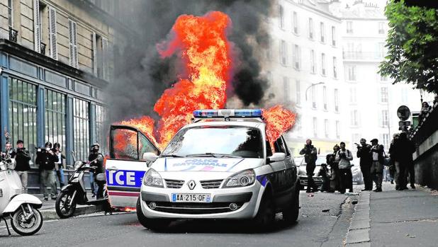 Manifestantes prenden fuego a un coche policial durante una protesta en París