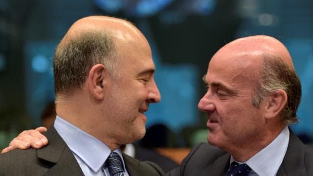 Pierre Moscovici, comisario de Asuntos Económicos, junto a Luis De Guindos en una reunión del Ecofin