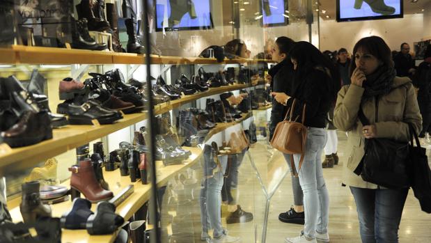 Paseantes observan un escaparate en una calle madrileña