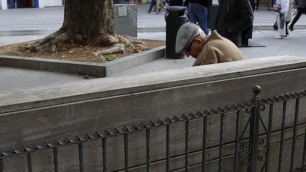 Un anciano, sentado en un banco