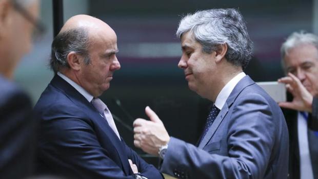 El ministro español de Economía, Luis de Guindos (i), conversa con su homólogo luso, Mario Centeno (d)