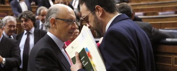 El portavoz del grupo socialista, Antonio Hernando (d), y el ministro de Hacienda, Cristóbal Montoro (i), al finalizar un pleno del Congreso de los Diputados