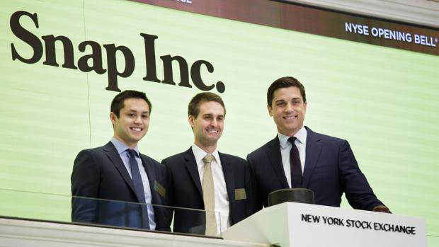 Los cofundadores de Snapchat, Bobby Murphy (i) y Evan Spiegel (c), posan para una fotografía junto al presidente de la Bolsa de Nueva York, Thomas W. Farley (d), durante la oferta pública de venta de Snap, la empresa matriz de Snapchat, en la Bolsa de Nueva York