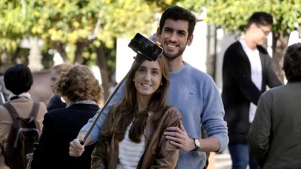 Una joven pareja de turistas se hace una autofoto en el Casco Histórico de Sevilla