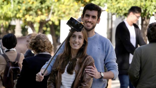 Una joven pareja de turistas se hace una autofoto en el Casco Histórico de Sevilla