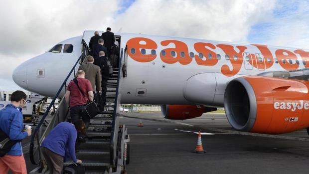 Varios pasajeros mientras embarcan en un avión de la aerolínea de bajo coste británica Easyjet, en Belfast