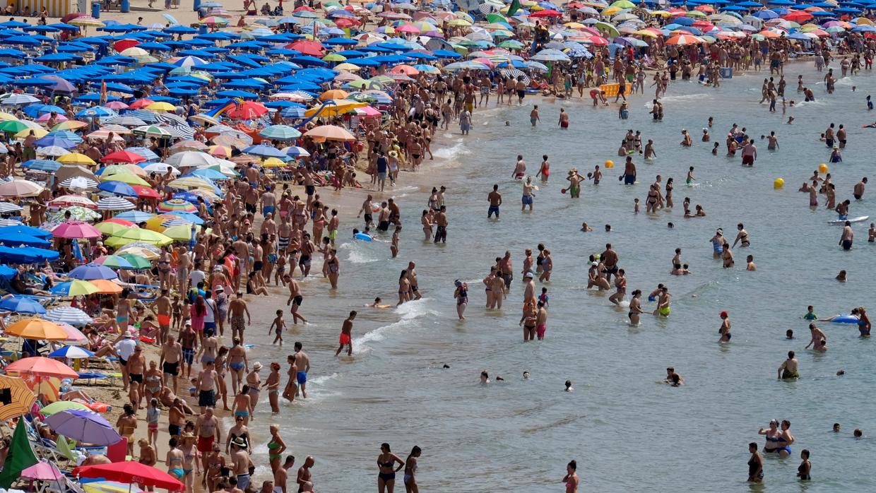 Varias personas toman el sol en la playa del Postiguet de Alicante