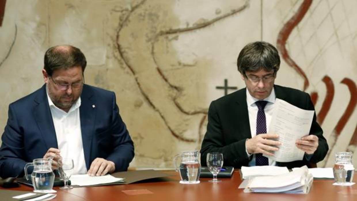 El presidente de la Generalitat, Carles Puigdemont, y su vicepresidente, Oriol Junqueras, durante la reunión semanal del gobierno catalán producida este martes