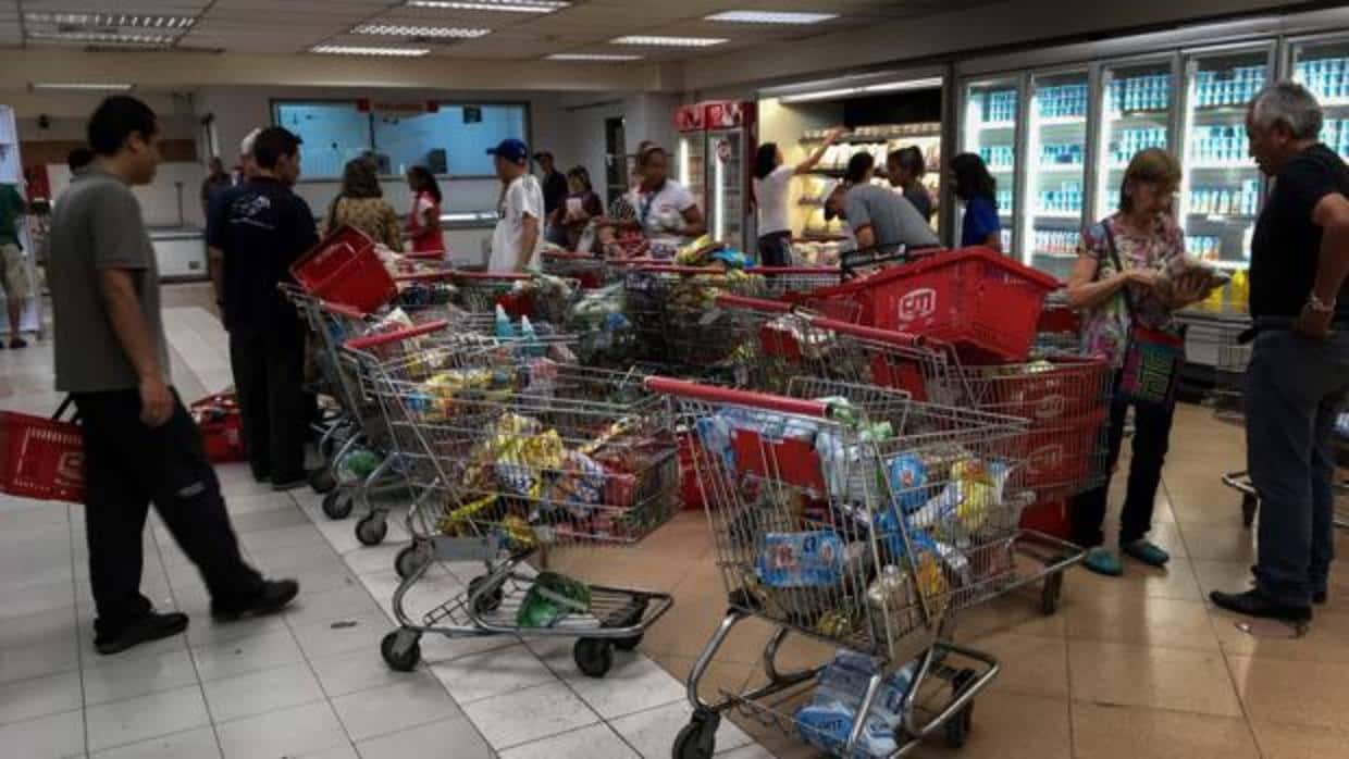 Venezolanos buscan alimentos en los pasillos de un supermercado