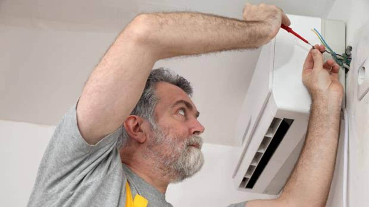 Un técnico repara un aparato de aire acondicionado