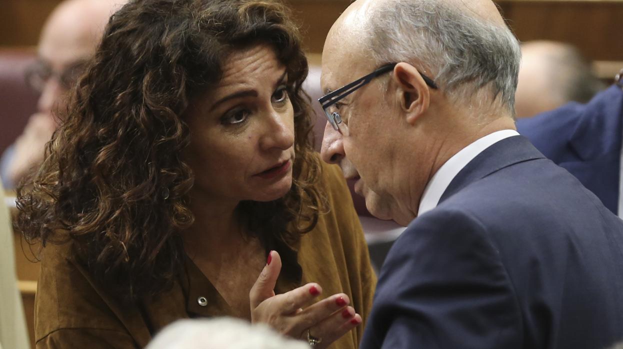 La ministra de Hacienda, María Jesús Montero, con su predecesor en el cargo, Cristóbal Montoro, ayer en el Congreso de los Diputados