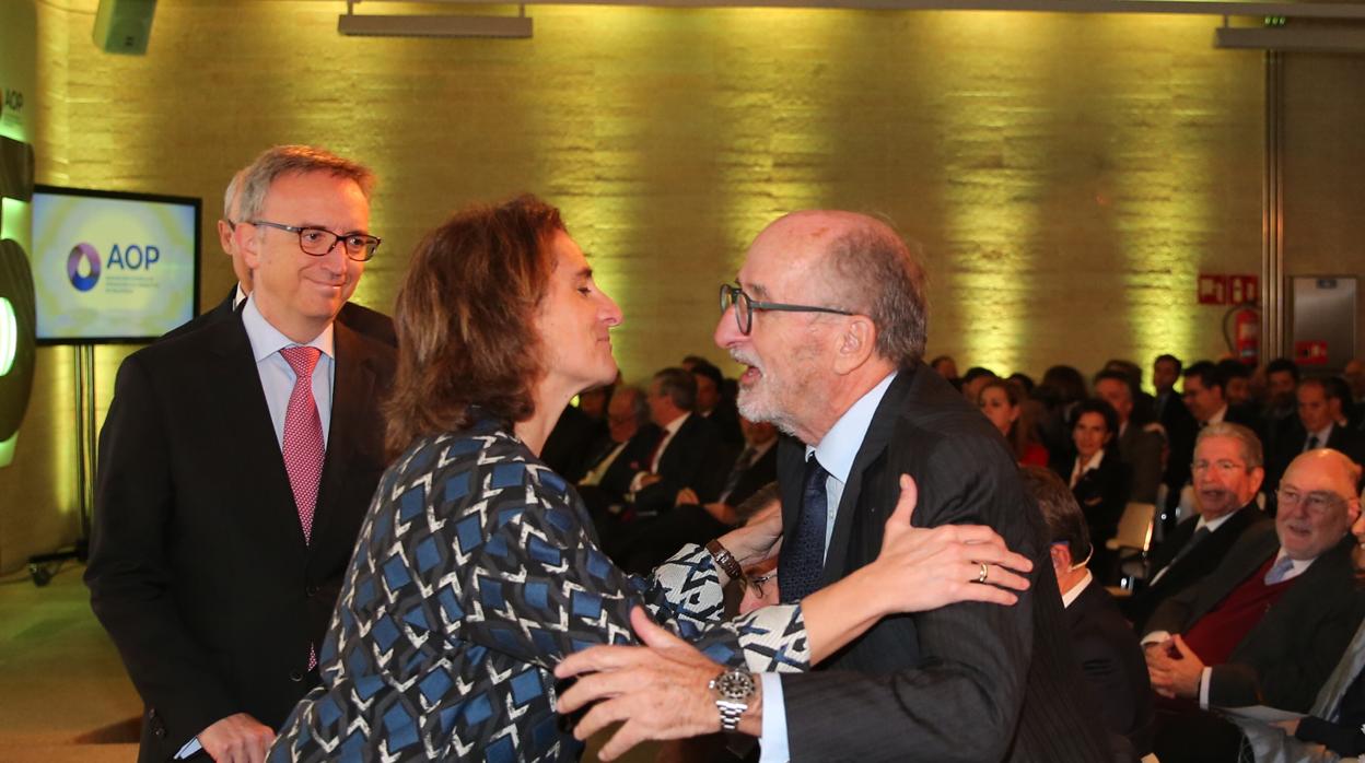 La ministra Teresa Ribera saluda al presidente de Repsol, Antonio Brufau, con el presidente de BP, Luis Aires, como testigo, al comienzo del acto