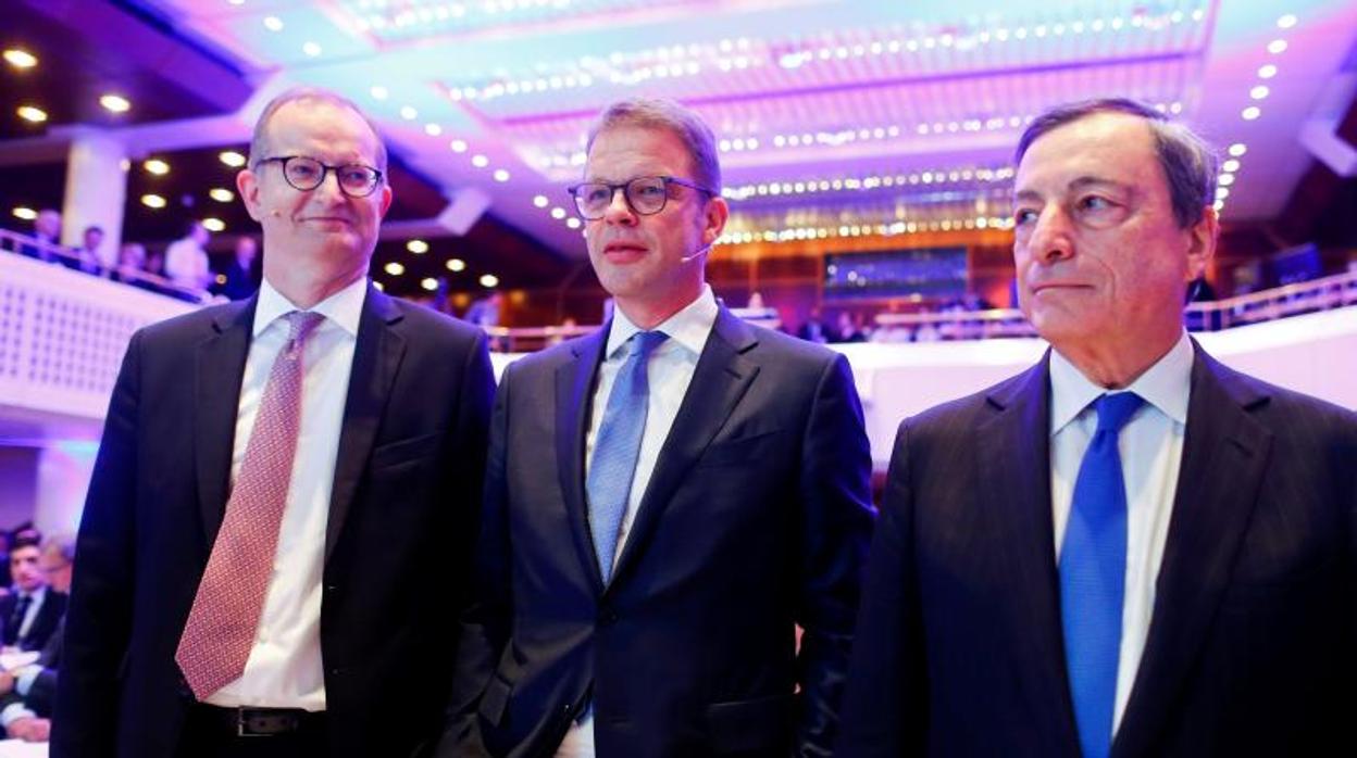 (De izda a dcha: El CEO del Commerzbank, Martin Zielke, junto a su homólogo del Deutsche Banki, Chirstian Sewing y el presidente del BCE, Mario Draghi