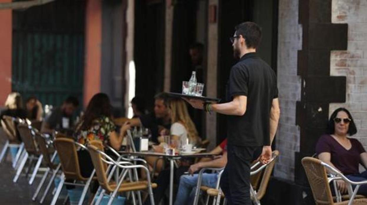 Un camarero atiende veladores en Córdoba