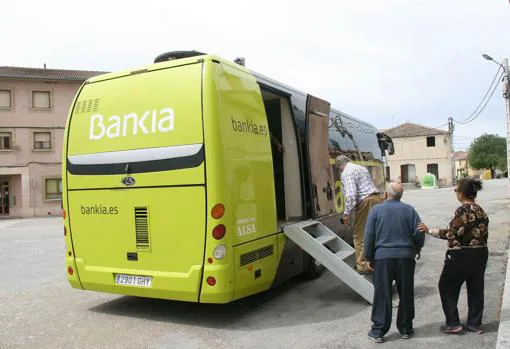 Varias personas mayores suben al autobús de Bankia en la localidad de Lastras de Lastras de Cuéllar (Segovia)