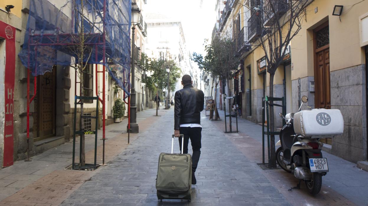 Un turista con su maleta en el barrio de Las Letras de Madrid