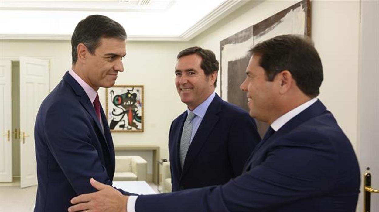 Sánchez saluda a Cuerva, en presencia de Garamendi, en agosto pasado en La Moncloa