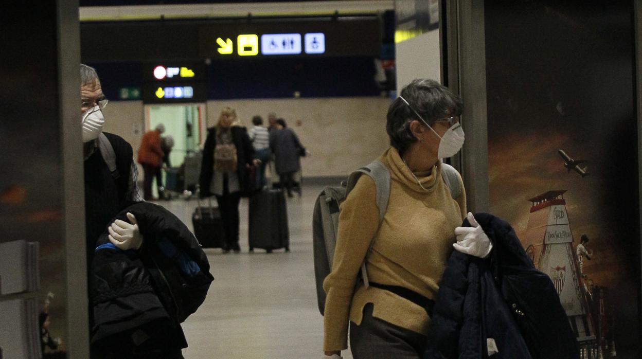 Dos viajeros con mascarilla en el aeropuerto de Sevilla