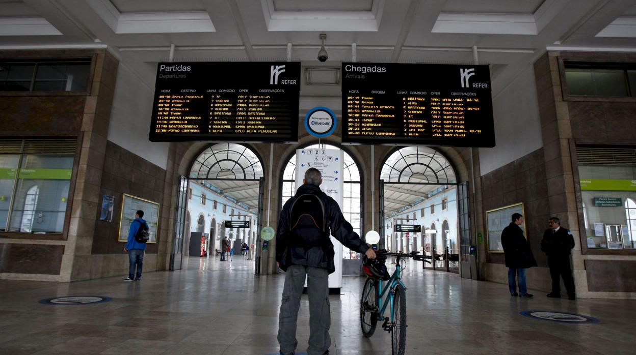 Un pasajero observa los trenes que salen y llegan de la estación lisboeta de Santa Apolonia