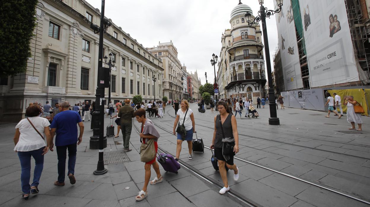 Turistas por Sevilla con sus maletas a cuestas