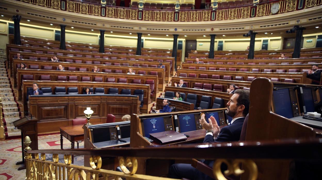 El líder del PP, Pablo Casado, y el resto de diputados aplauden la intervención del presidente del Gobierno, Pedro Sánchez, que comparece en el Congreso para explicar la declaración del estado de alarma y las medidas para paliar las consecuencias de la pandemia provocada por el coronavirus