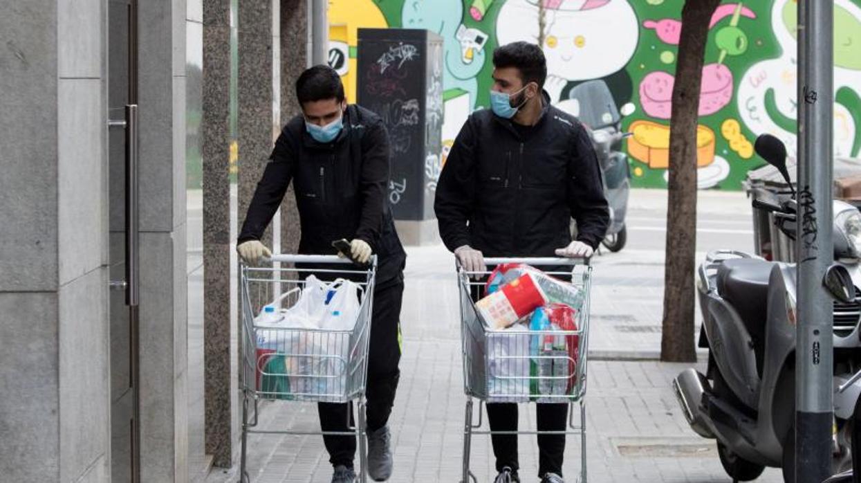 Dos trabajadores de supermercado llevan la compra a domicilio