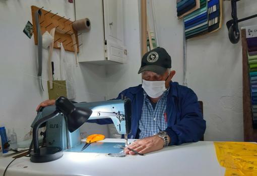 Con 17 años, Gerardo Gómez abrió la tapicería El Desván (Huelva), ahora en horas bajas por el coronavirus. Desde mediados de marzo, este autónomo pasa los días en el taller fabricando mascarillas y calzas solidarias