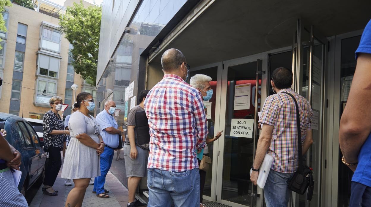 Varias personas esperan ser atendidas en una oficina de la Seguridad Social en Madrid