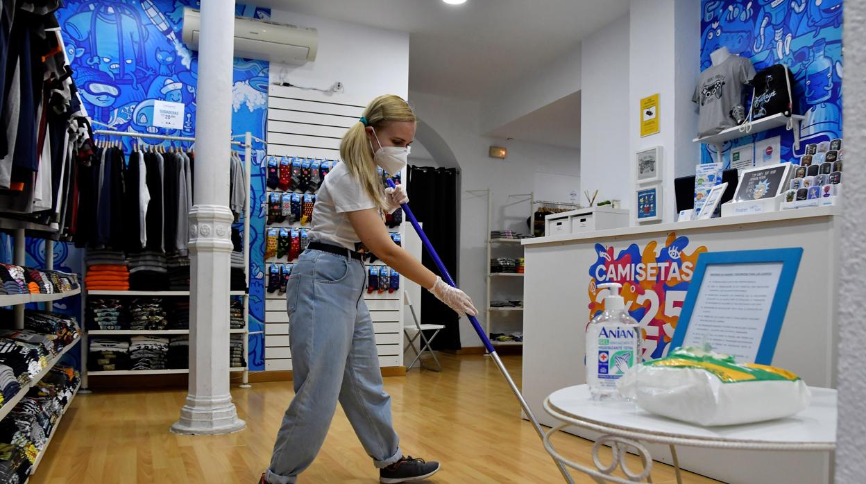 La dueña de una tienda hace una limpieza en su comercio como medida de prevención del Covid-19