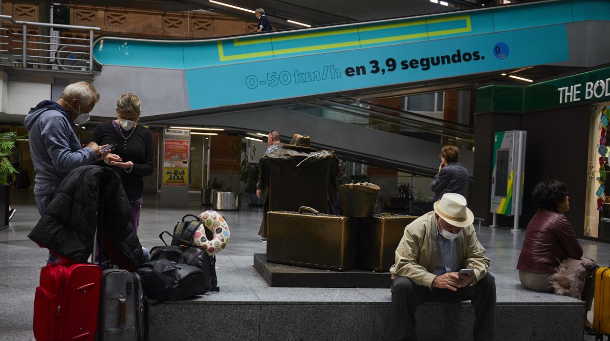 Pasajeros esperan en la estación de Atocha, Madrid