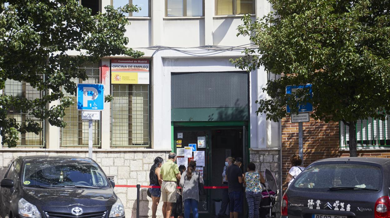 Varios ciudadanos esperan que les atiendan en una oficina de Empleo en Madrid