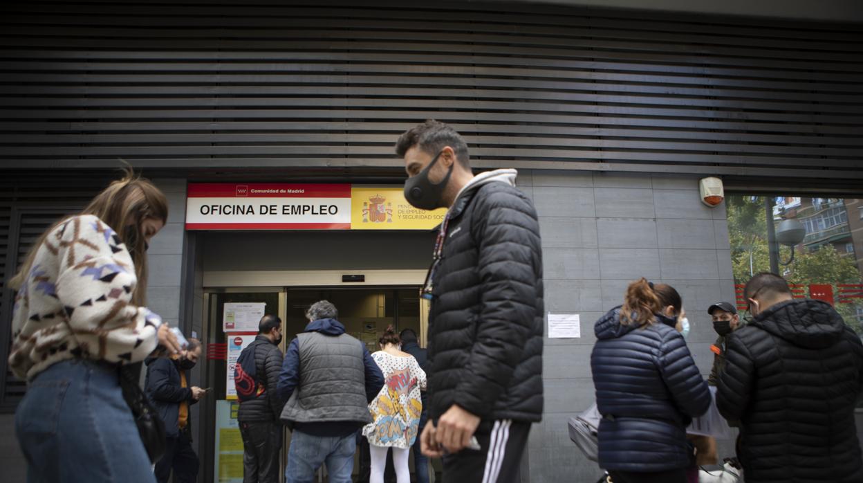 Varias personas esperan ser atendidas en una oficina de empleo en Madrid