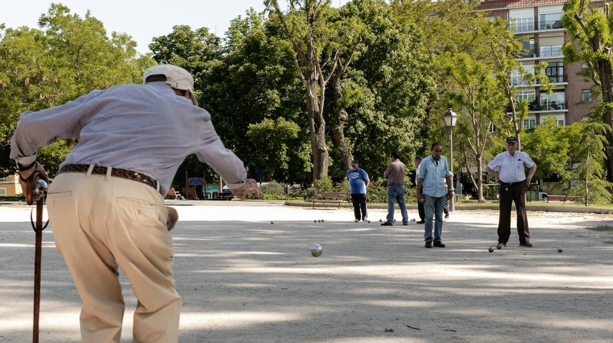 Jubilados jugando a la petanca en un parque público