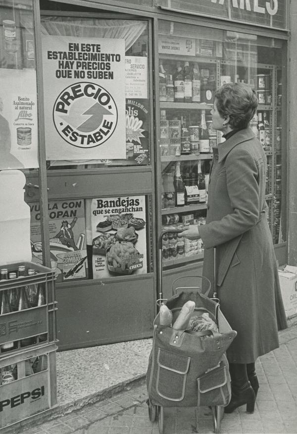 En España, el IPC creció un 26,4% en 1977. Al año siguiente, el Ministerio de Consumo lanzó la campaña ‘Precio Estable’. Una mujer observa su anuncio en una tienda de Madrid