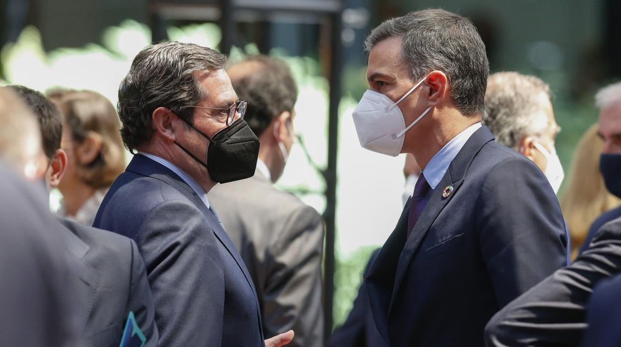 El presidente del Gobierno, Pedro Sánchez (d), conversa con el presidente de la CEOE, Antonio Garamendi