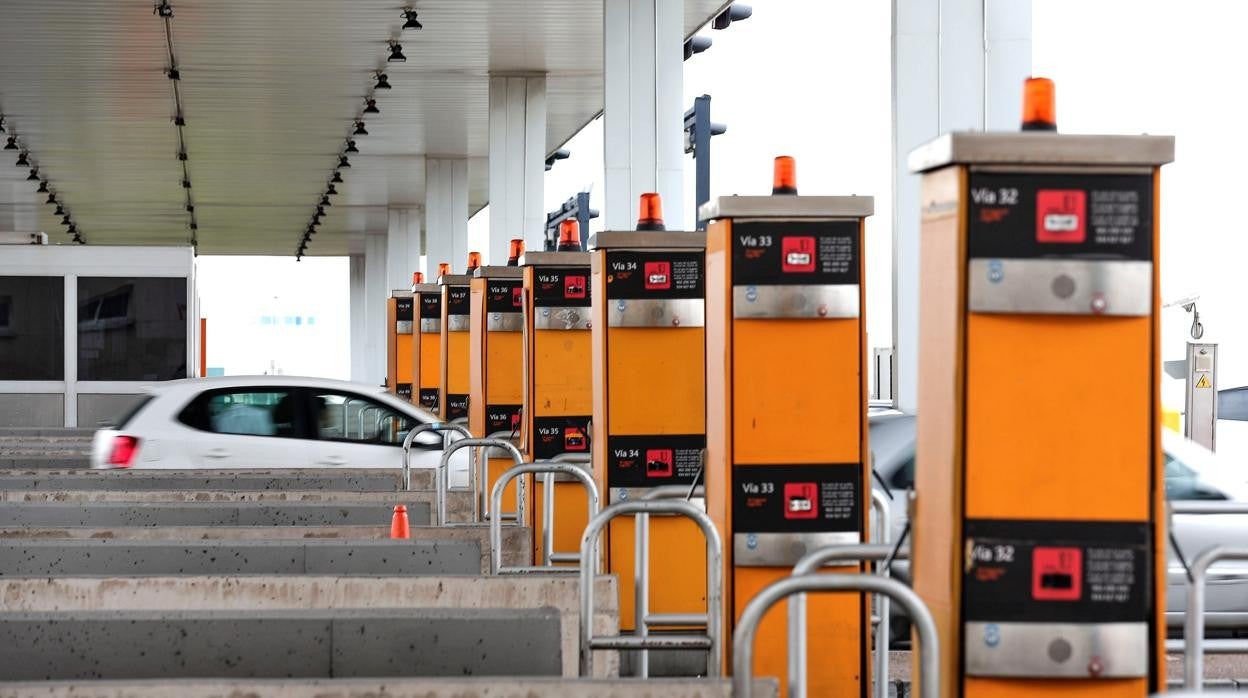 Varios vehículos cruzan el área de peaje de la autopìsta AP-7 en Sagunto (Valencia)