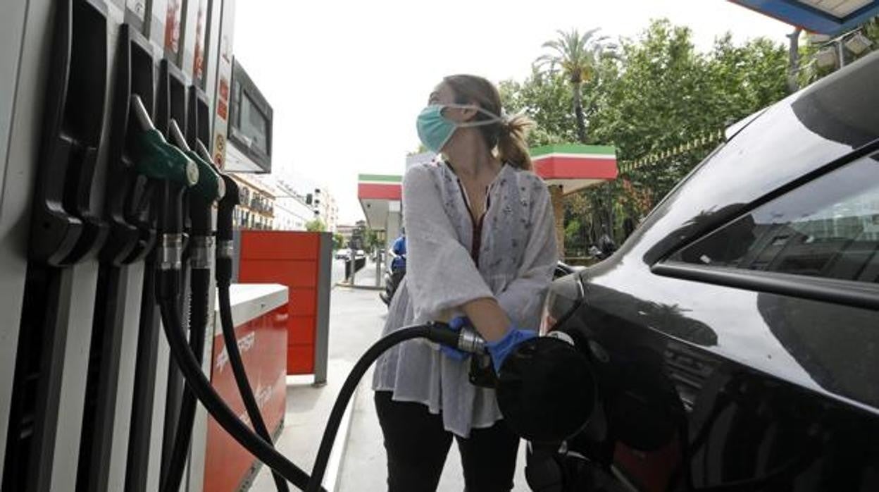 Una mujer reposta en una gasolinera