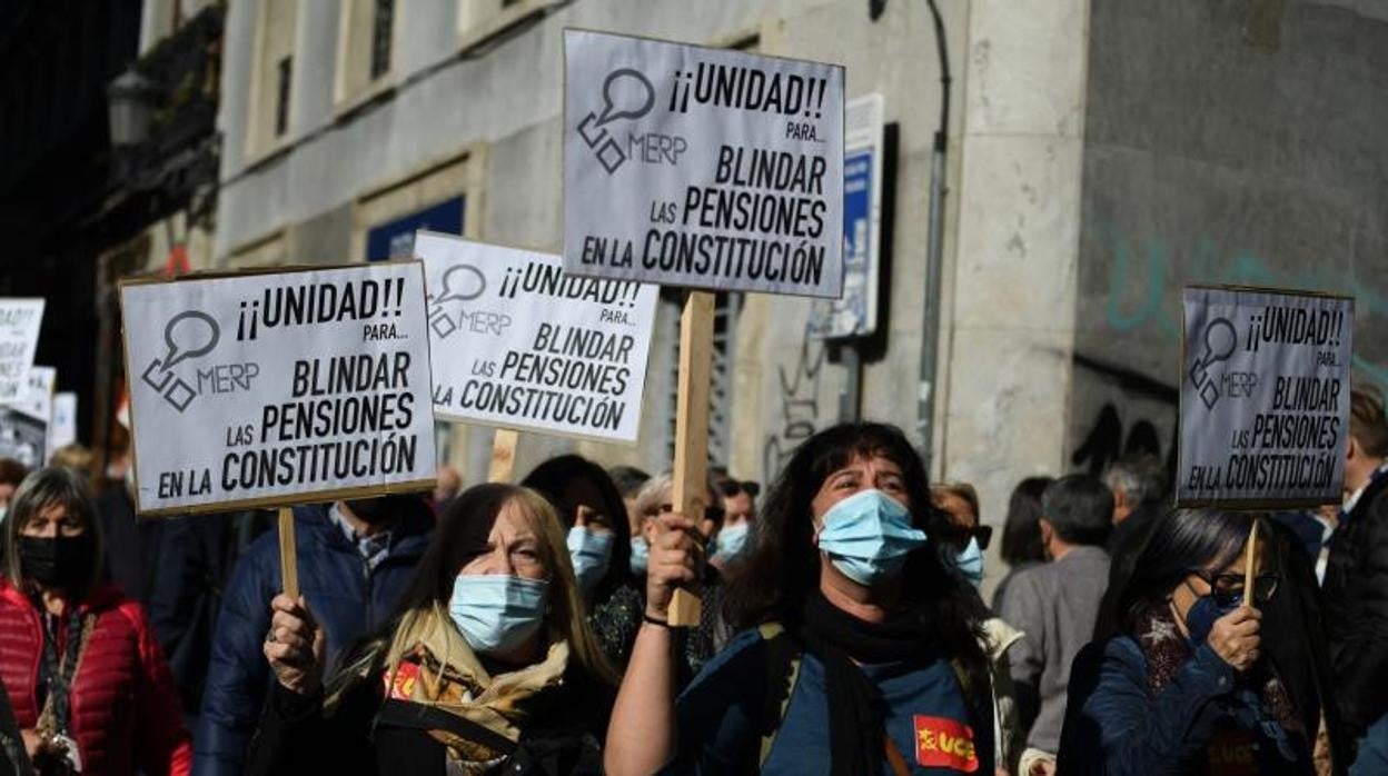 Asistentes con pancartas donde se puede leer «Blindemos las pensiones» durante una manifestación que reclama el blindaje de las pensiones en la Constitución