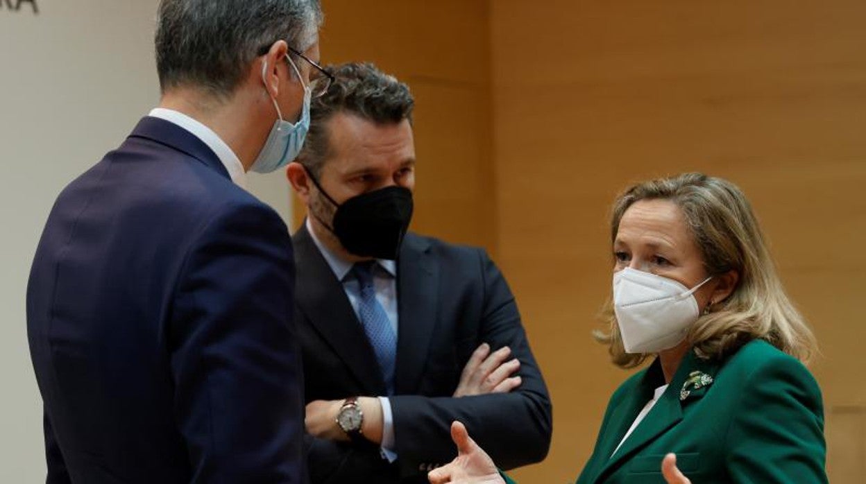 De espaldas, Pablo Hernández de Cos, gobernador del Banco de España; en el centro, el presidente de la CNMV, Rodrigo Buenaventura; y Nadia Calviño, vicepresidenta económica