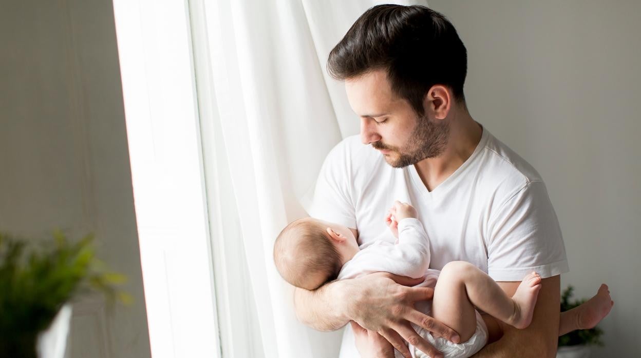 Un padre sostiene a su bebé.