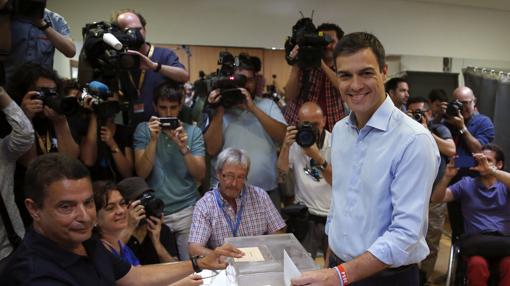 Pedro Sánchez vota con una camisa azul claro y pantalones de pinza azul marino