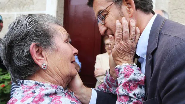 Una vecina de Os Peares (Orense) pueblo natal de Feijóo, saluda cariñosa al candidato del PP a la Xunta de Galicia