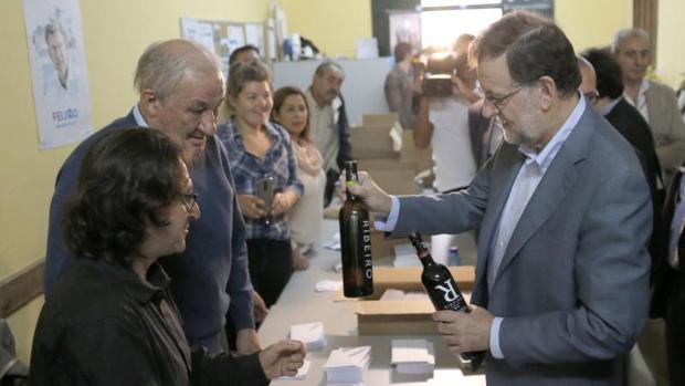 El presidente del Gobierno, Mariano Rajoy, recibe como regalo dos botellas de Ribeiro, en la sede local del PP